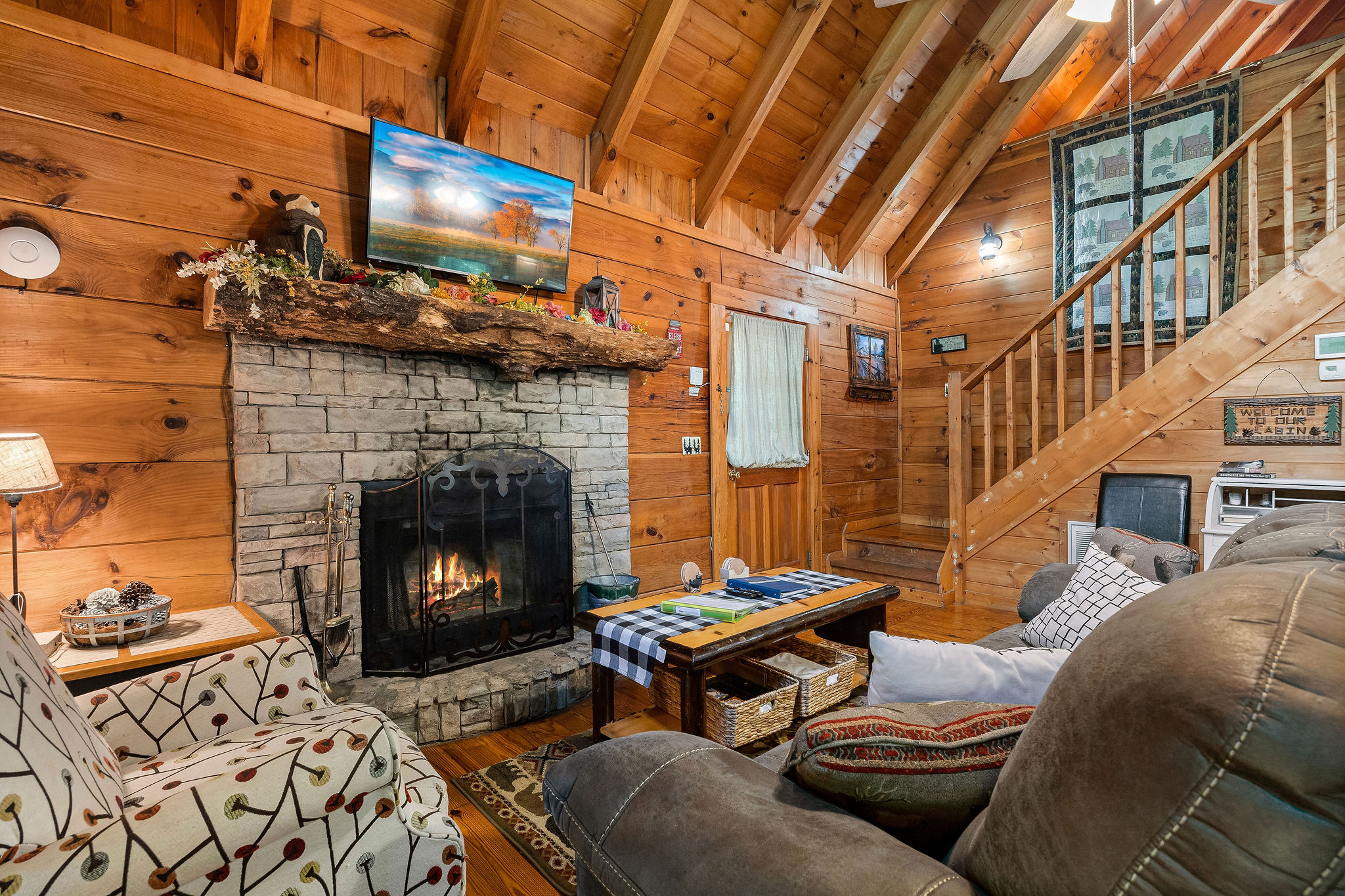 Living room with fireplace, tv, and deck access at Cloud 9, a 1-bedroom cabin rental located in Pigeon Forge