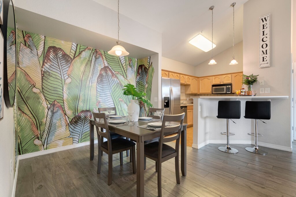 Kitchen and Dining Area with Vaulted Ceilings and Mural Wall