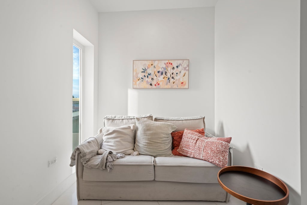 Unwind in this inviting living room, featuring a plush sofa and stylish decor - Soft, cozy cushions and warm tones make this the perfect spot to relax - Whether you're reading, chatting, or streaming your favorite shows, comfort is guaranteed