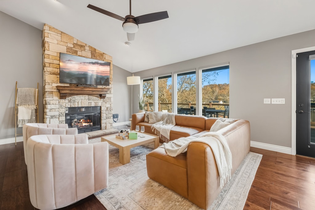 Open concept living room with a fireplace and large windows with a view.