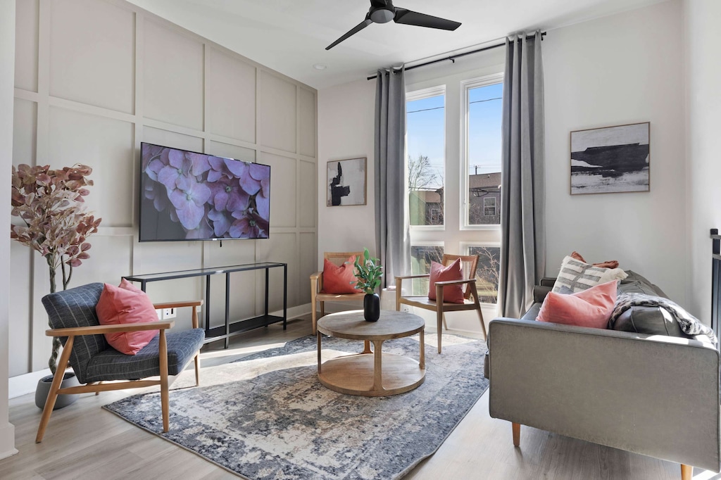 Stylish living room featuring a wall-mounted smart TV, a sleek leather couch, a modern coffee table, and three elegant accent chairs for a cozy and inviting ambiance.