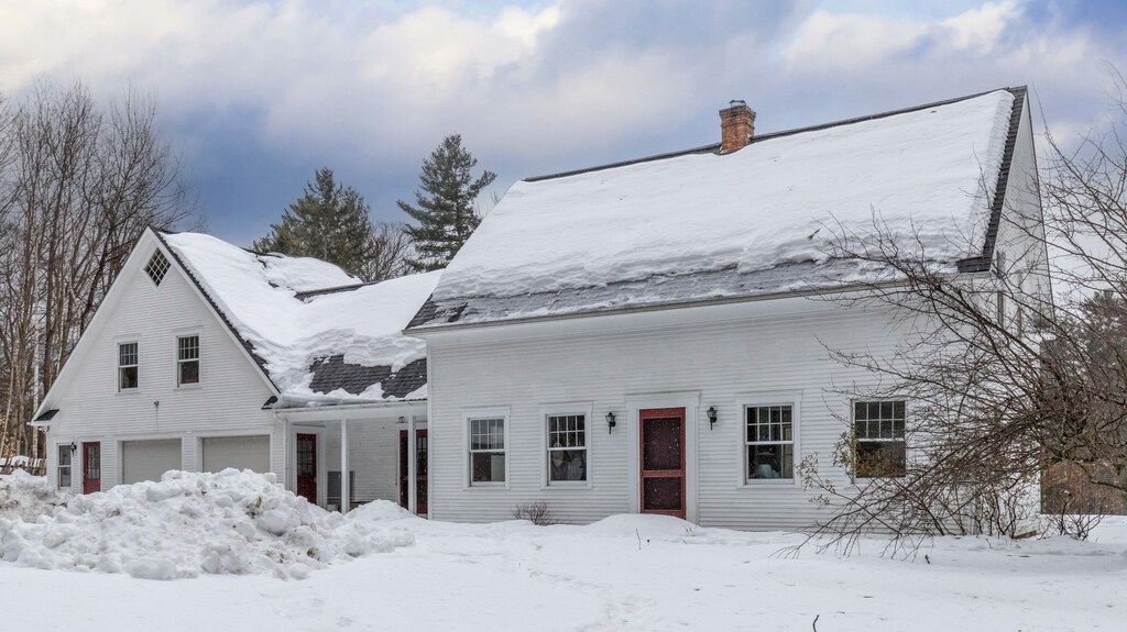 - Snow-covered exterior highlights peaceful mountain getaway   - Large windows and red doors add welcoming rustic character   - Serene setting perfect for winter ski trips and family stays