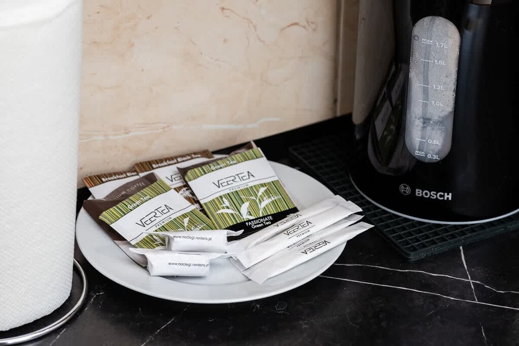 A close-up of a tray with coffee, tea, and sugar, complemented by an electric kettle for guest convenience.