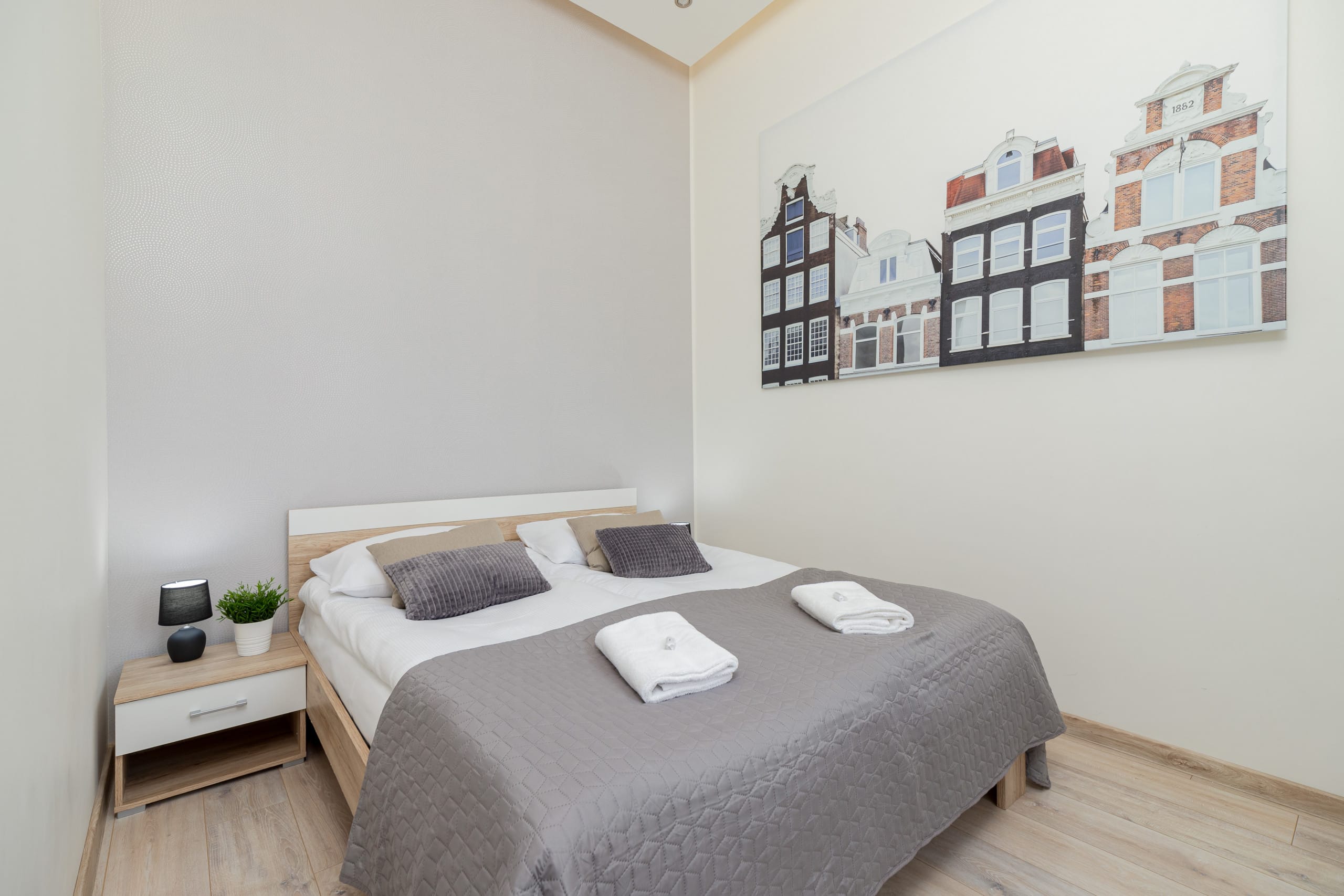 Cozy bedroom with a double bed, gray bedding, and stylish wall decor.
