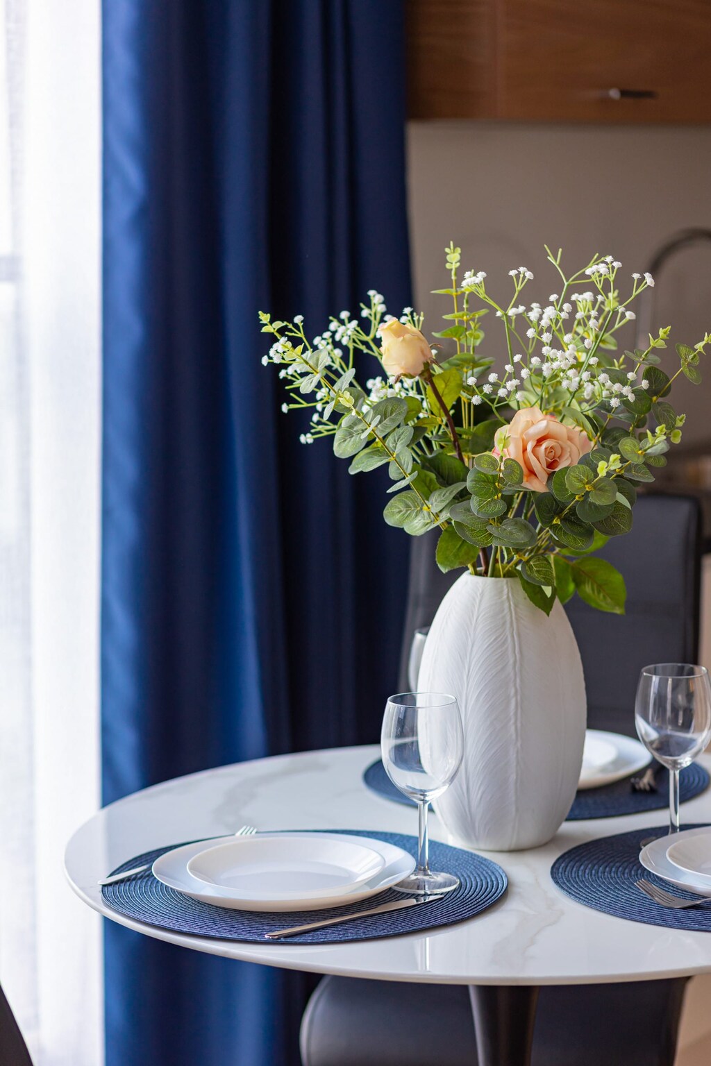 A dining table set with a vase of fresh flowers and elegant tableware.
