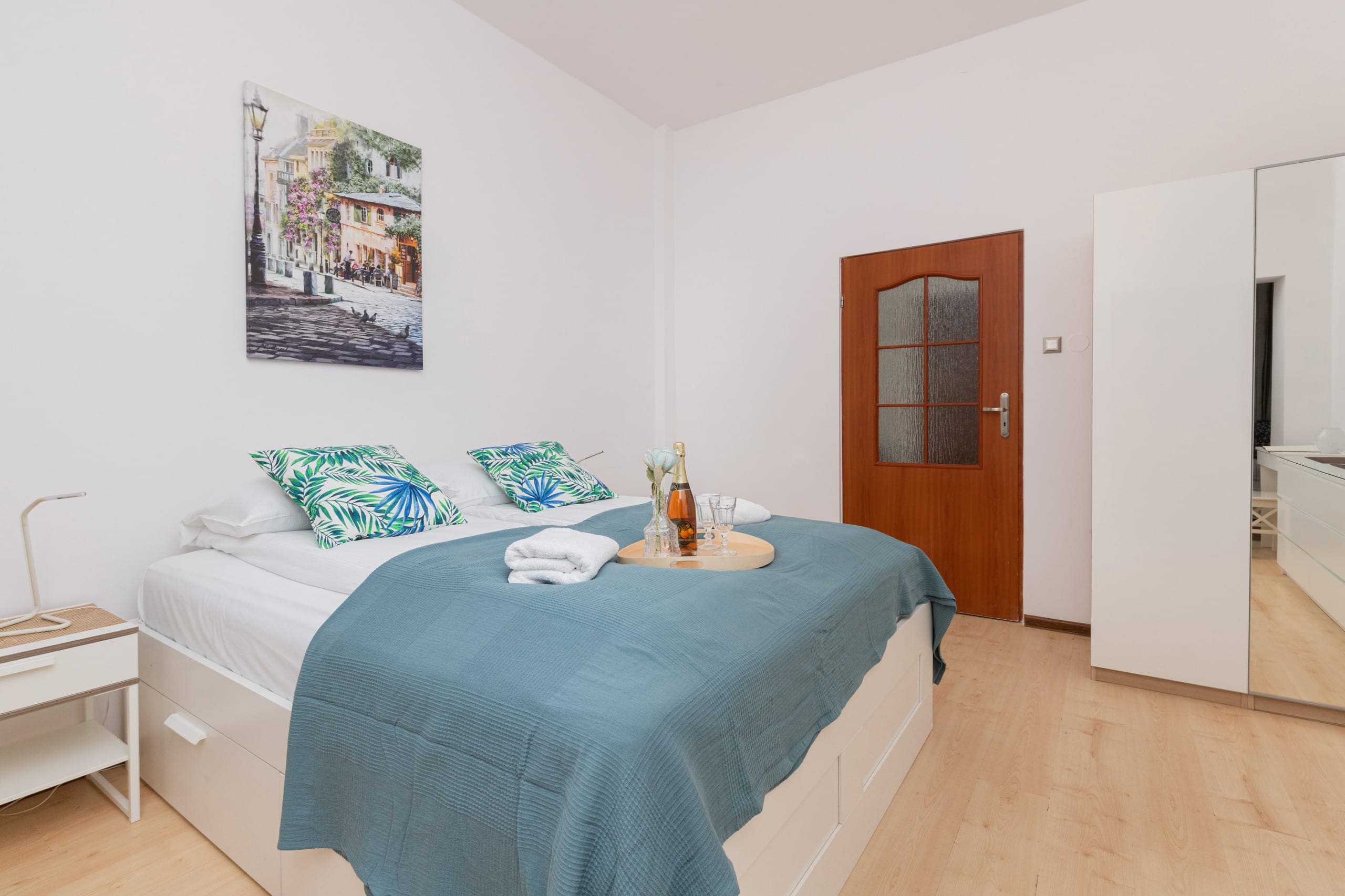 A bedroom with a double bed, blue bedding, and a cozy corner for relaxation.
