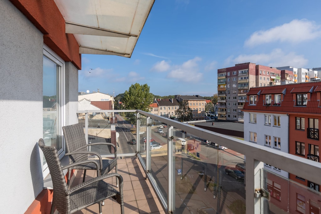 Spacious balcony with outdoor seating offering picturesque city views.
