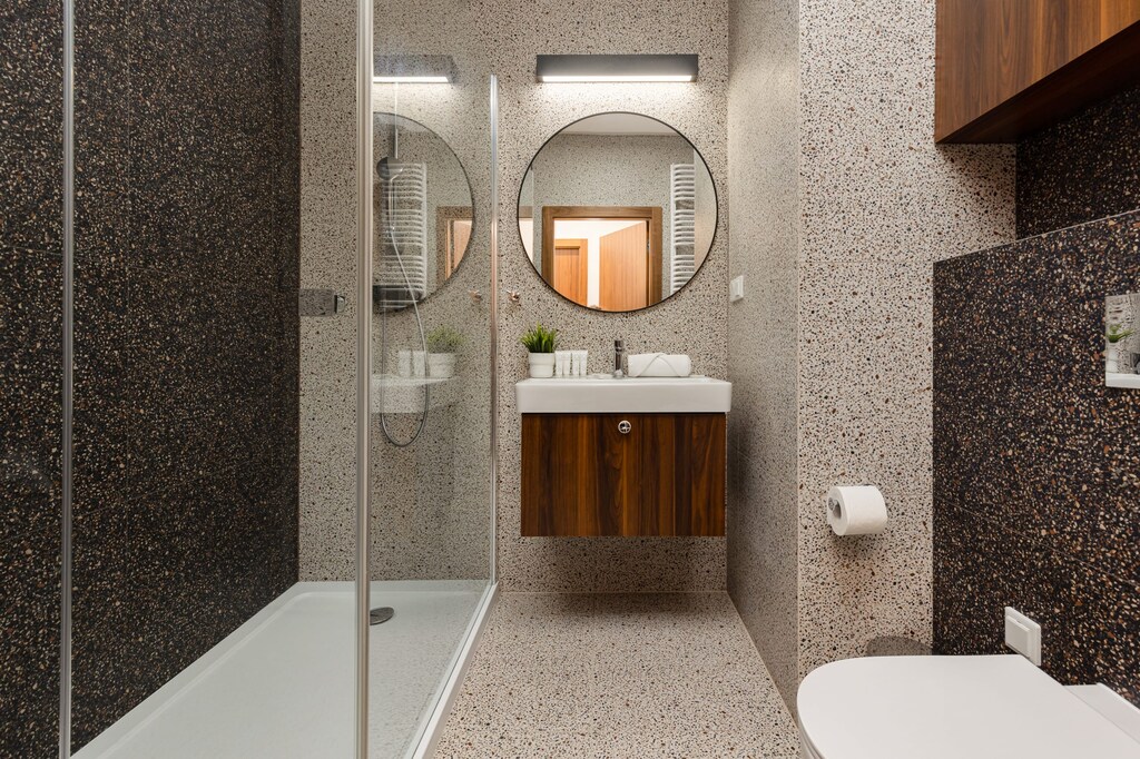 Stylish bathroom with a walk-in shower, mosaic tiles, and elegant fixtures, offering a luxurious feel.
