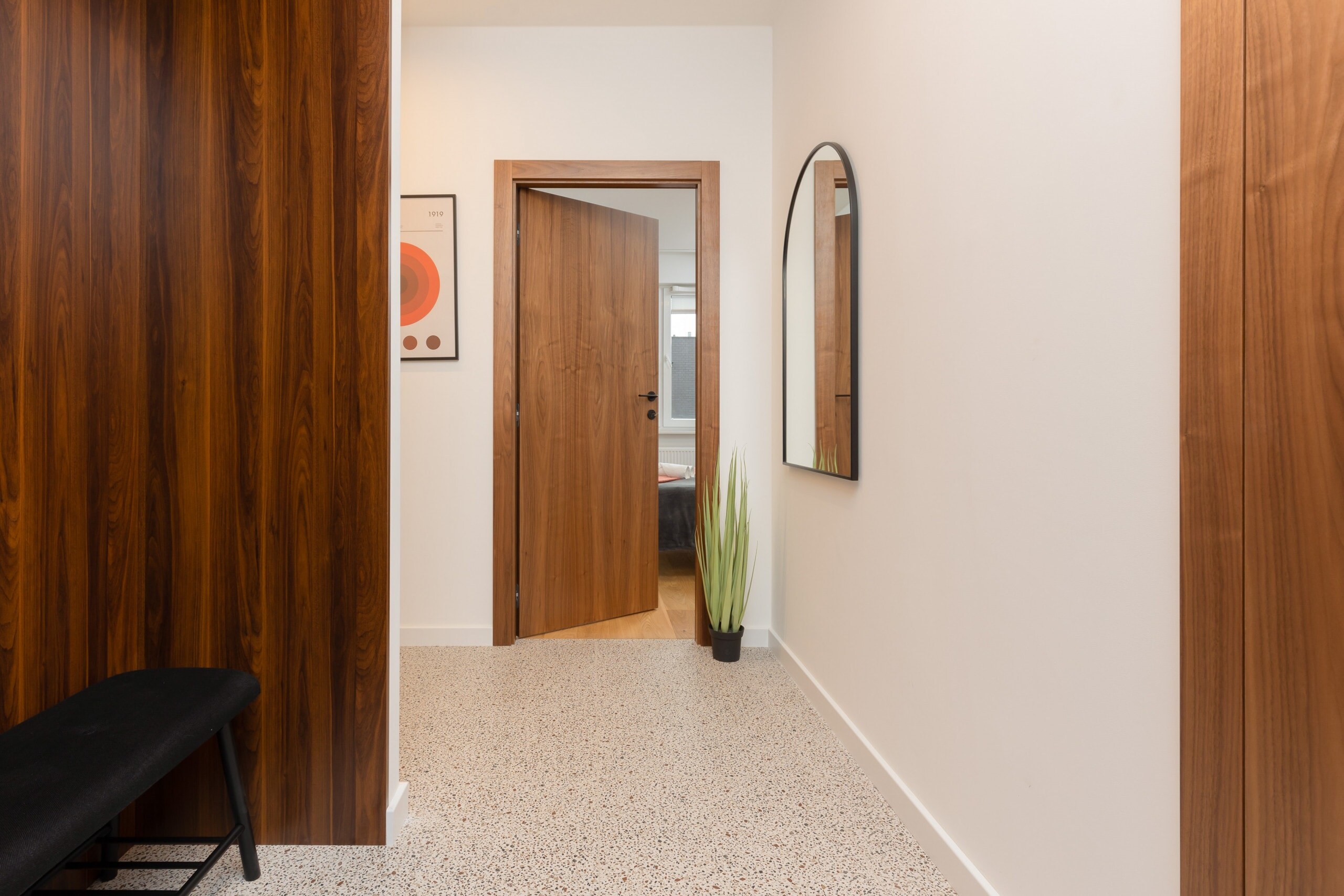 Entryway with a large mirror, wooden accents, and a stylish bench, creating a welcoming first impression.
