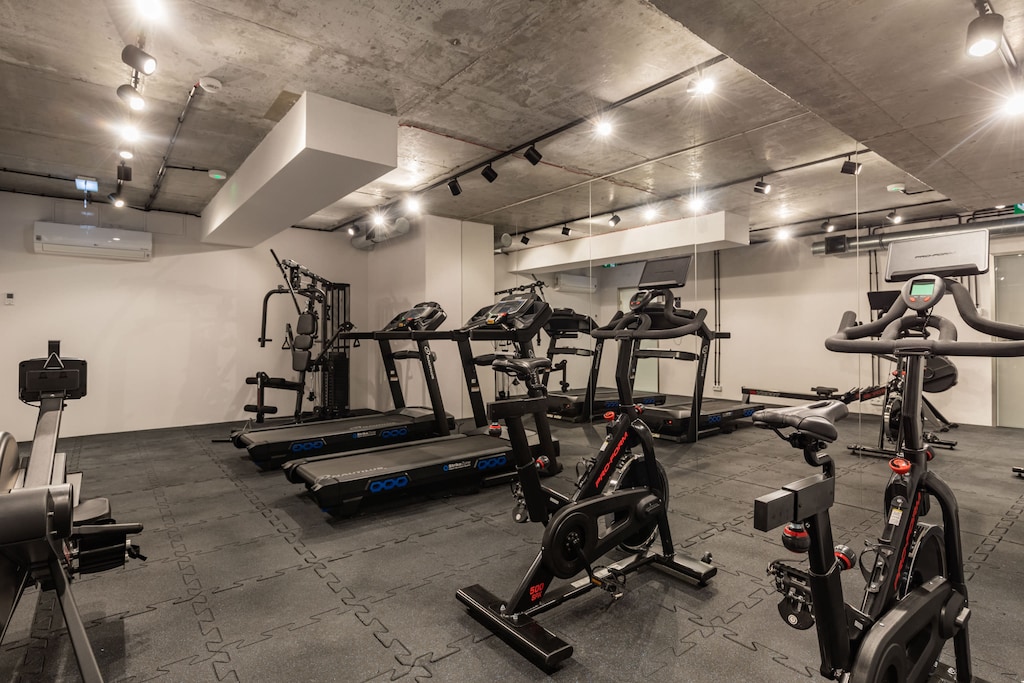 A gym with exercise equipment such as running treadmills and stationary bikes.