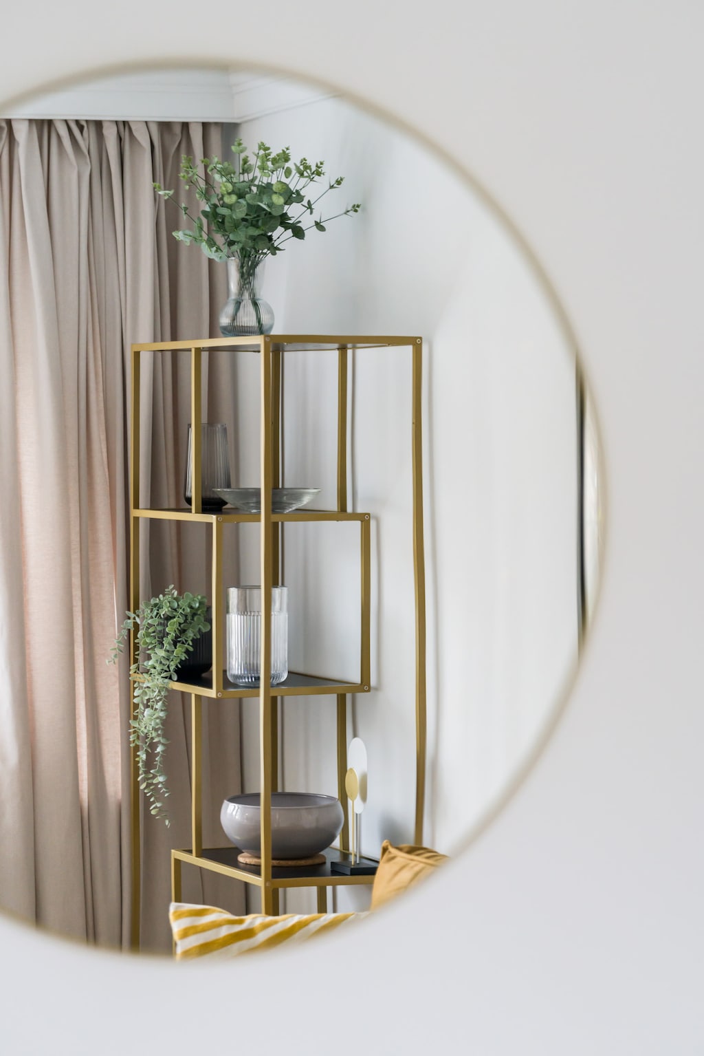 A decorative mirror with a gold frame and stylish shelving, adding an elegant touch to the decor.

