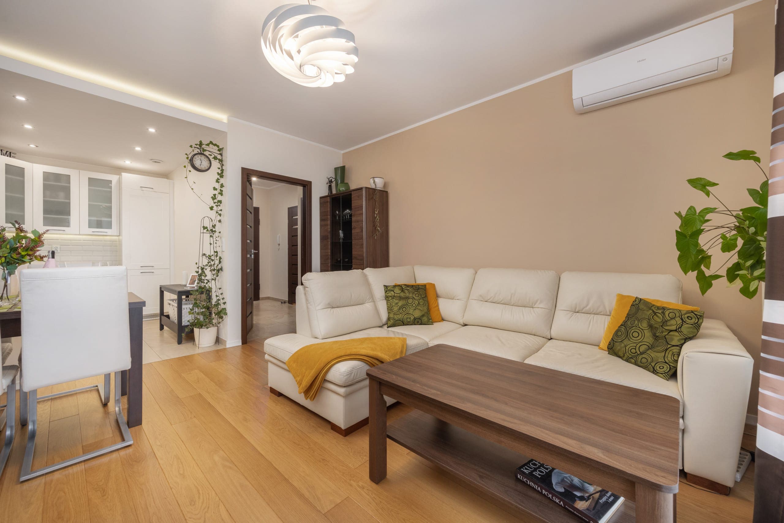 Spacious living room with a beige sofa, modern decor, and bright natural lighting.
