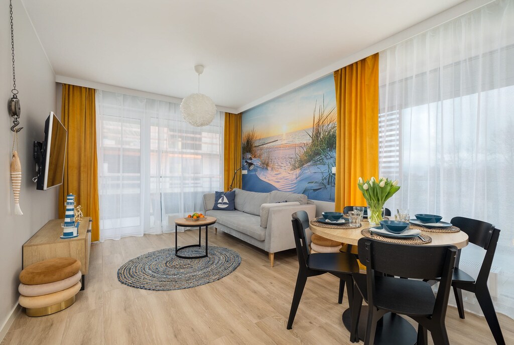 The bright living room with large windows that let in plenty of natural light creates a great space to relax with a sofa and TV.