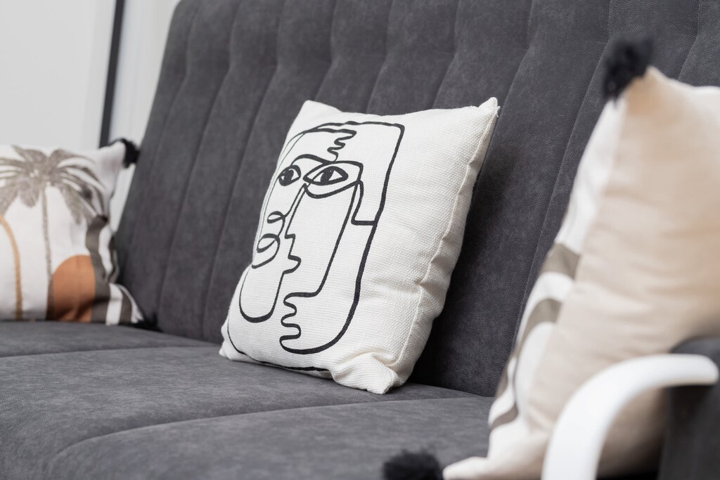 Modern living room with a comfortable grey sofa, a stylish coffee table, and large windows providing plenty of natural light.
