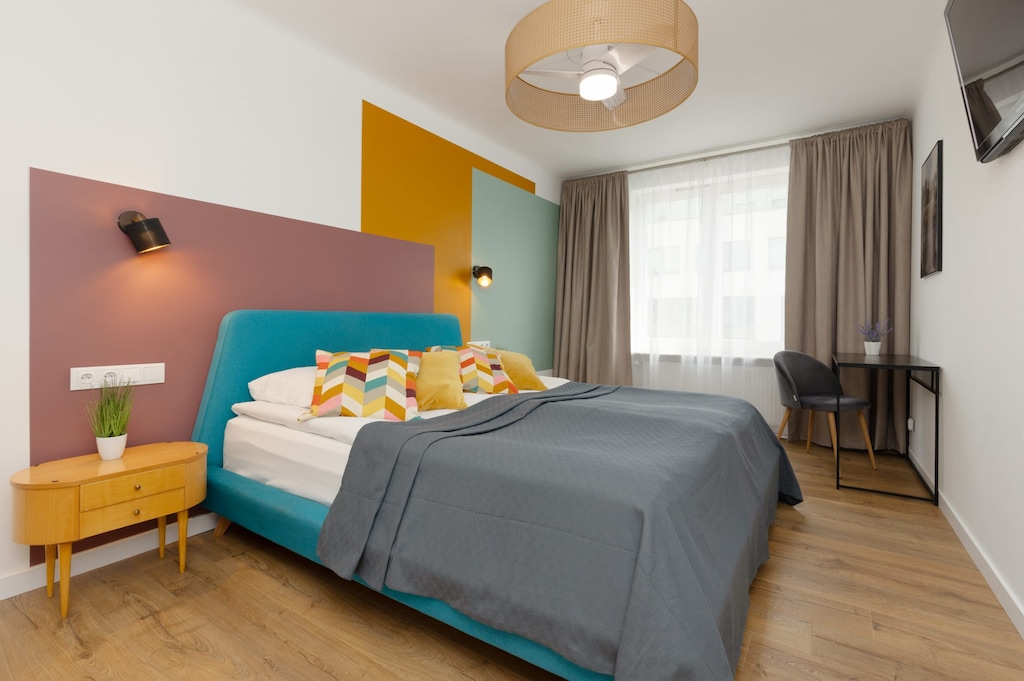 A bright bedroom with a comfortable bed, colorful walls, and stylish decor.

