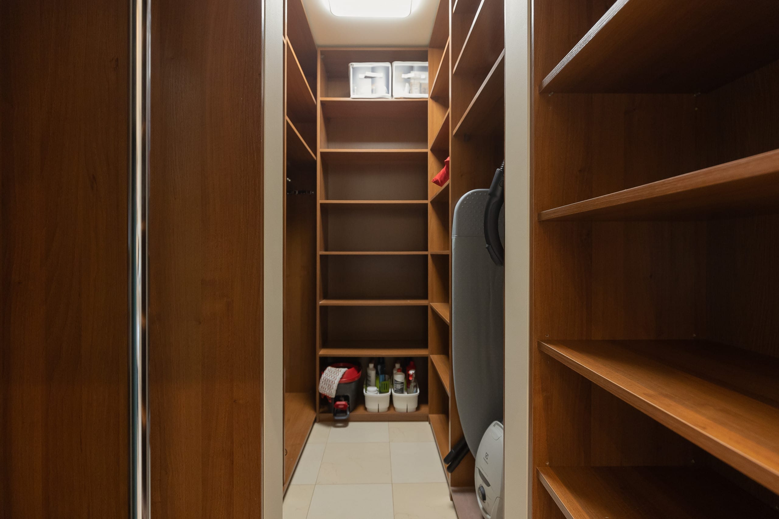 A spacious walk-in closet with wooden shelves and ample storage space.
