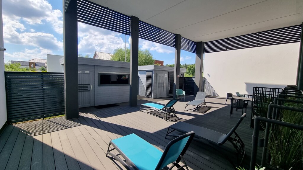 A patio or balcony with a dining table and chairs, surrounded by a scenic outdoor view.