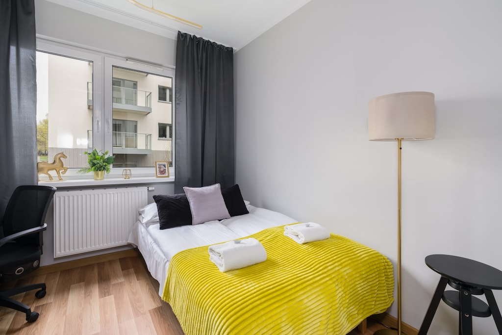 The stylish bedroom includes a comfortable sofa bed and a wardrobe.