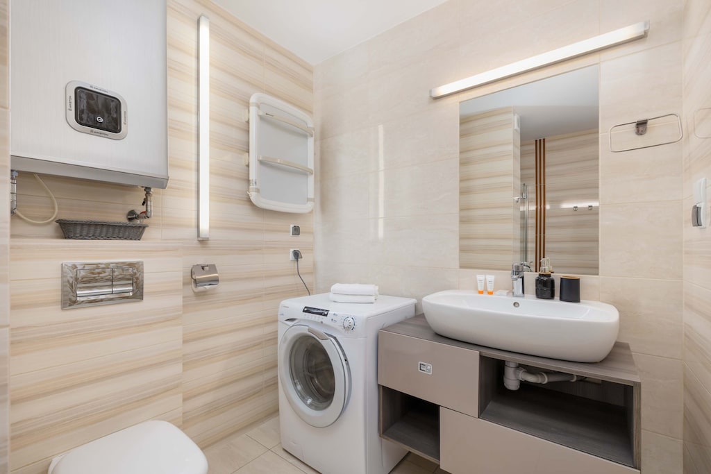 Bathroom with shower and washing machine.