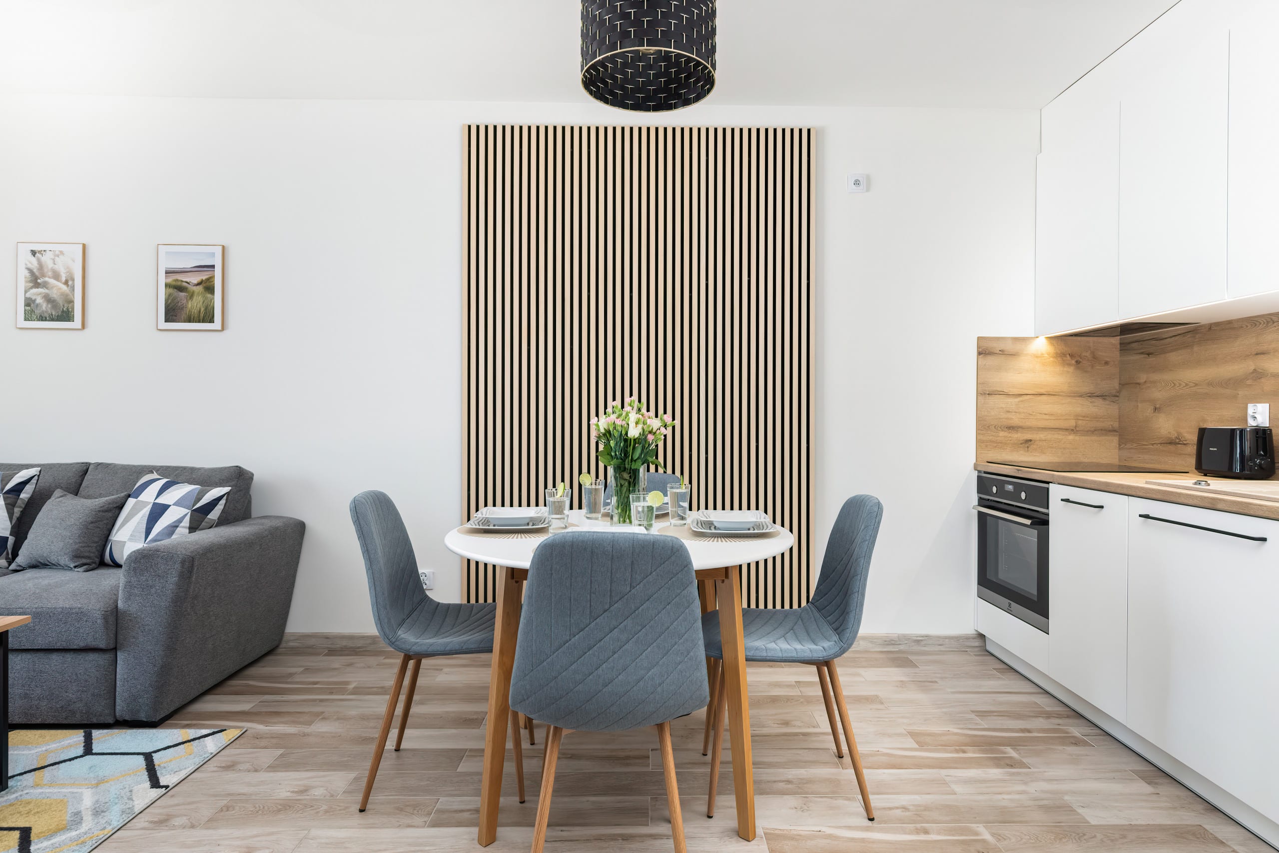 A spacious open-plan area with a dining table, modern kitchen, and living room that flows seamlessly together.

