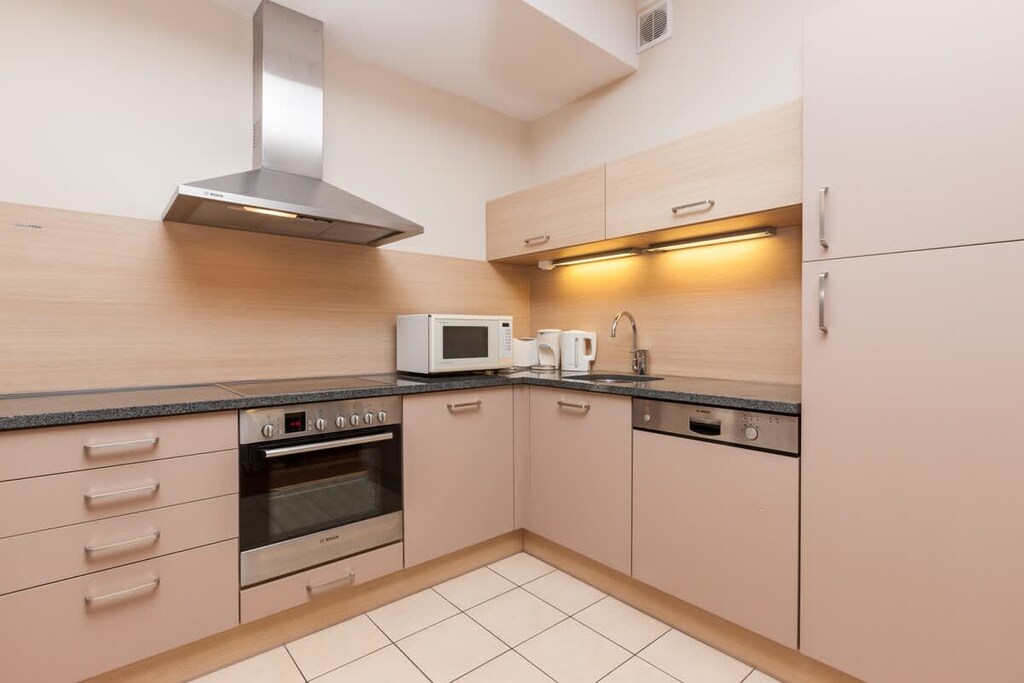 A fully equipped kitchen with stainless steel appliances and beige cabinetry.
