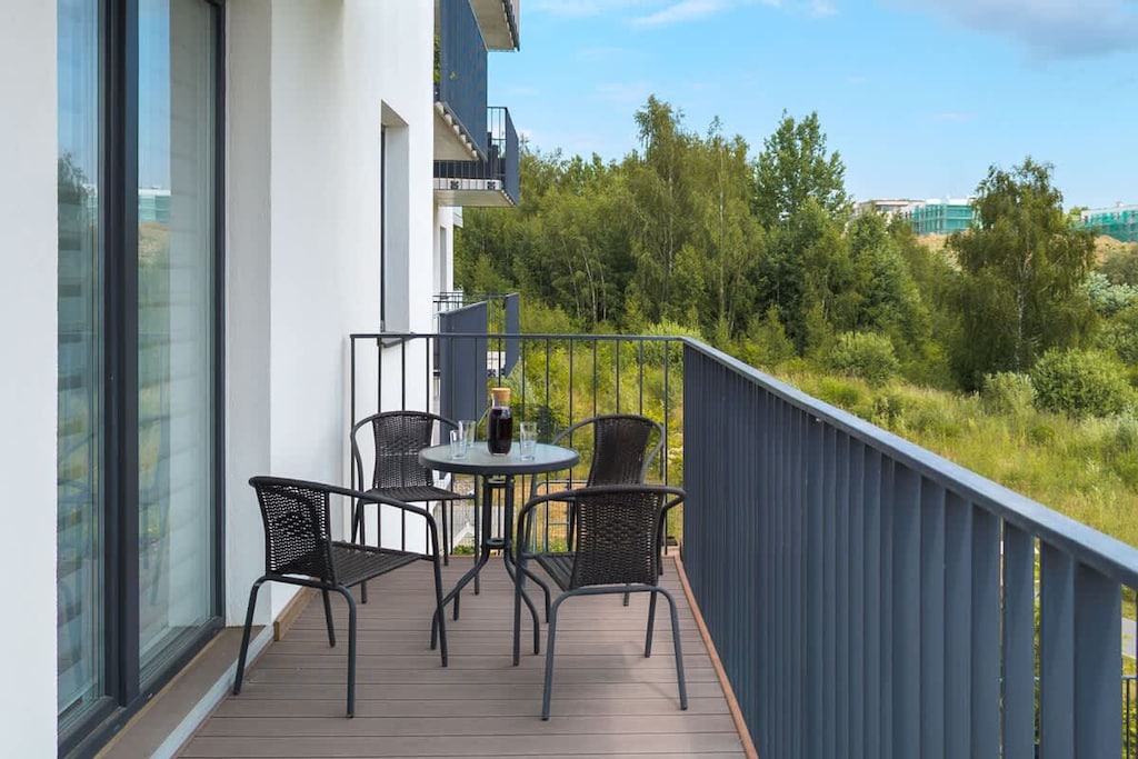 A private balcony with outdoor furniture and a view of greenery, perfect for relaxing outdoors.
