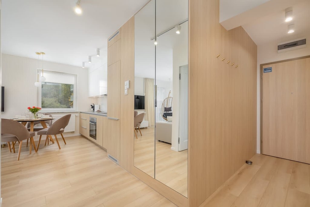 A hallway with wooden accents, built-in storage, and a view into the open-plan living area.
