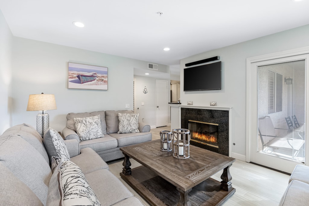 The inviting living room features a television, fireplace, and a queen-sleep sofa.