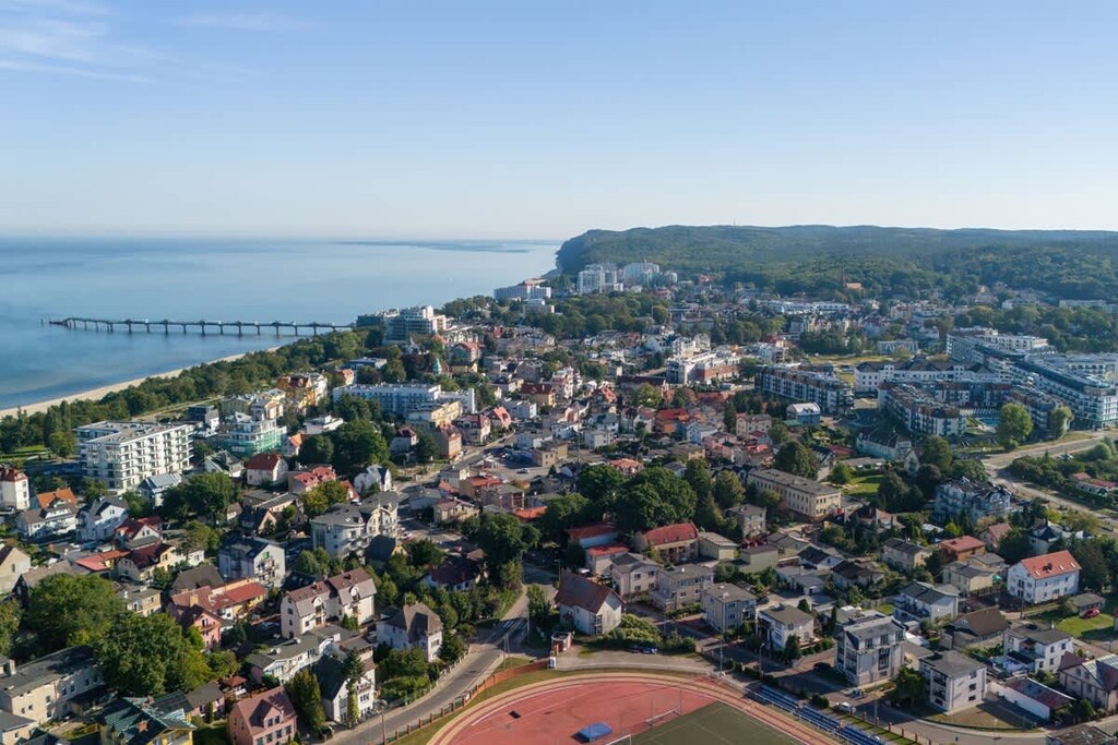 An expansive aerial view of the “Bel Mare” complex and surrounding coastline, showcasing pools, walkways, and adjacent buildings.