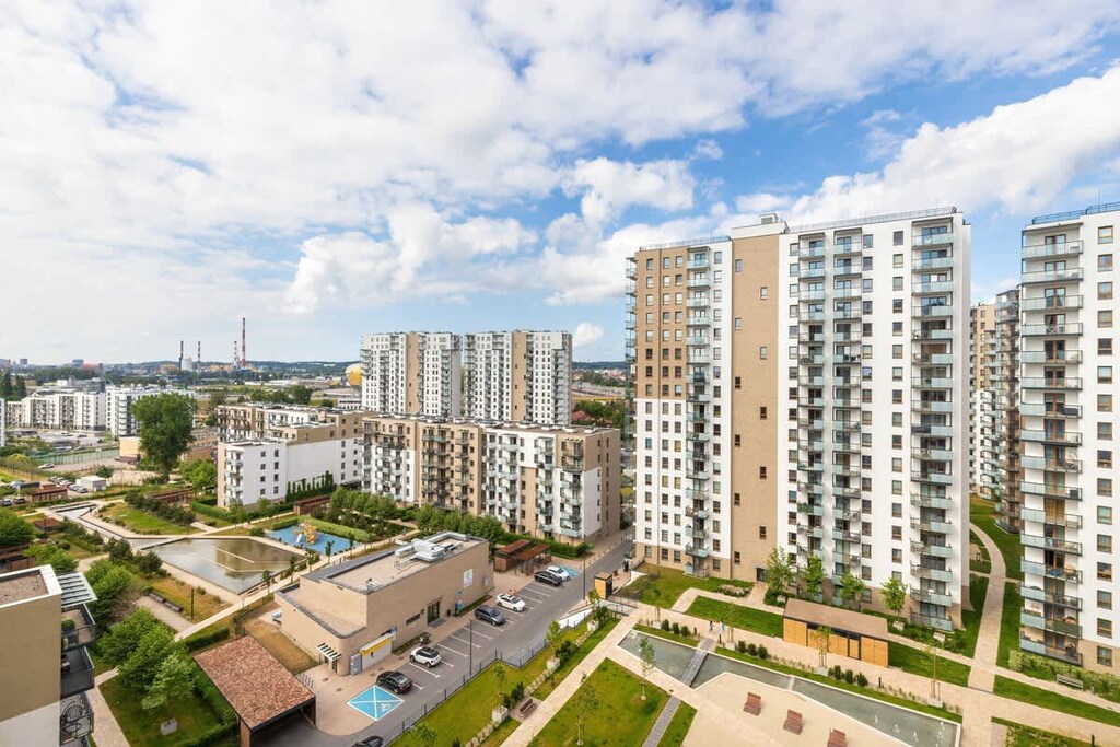 A view from the balcony showing a courtyard surrounded by modern residential buildings.

