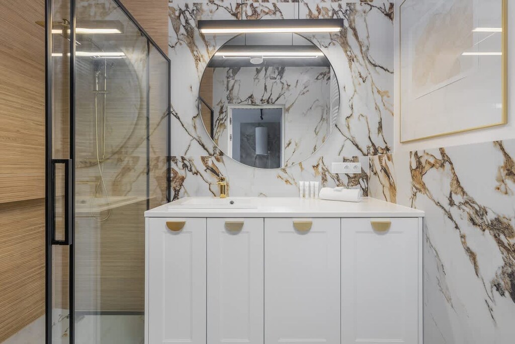 The bathroom's contemporary design includes fresh towels and a hairdryer. 