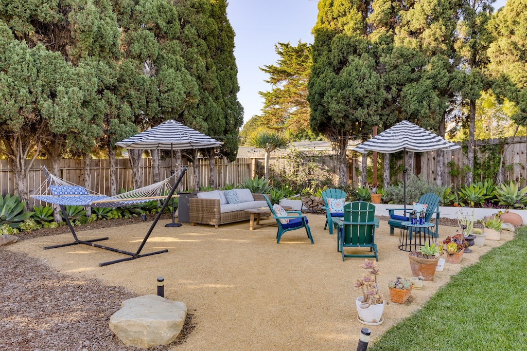 Spacious patio with seating, a fire pit, and a hammock.