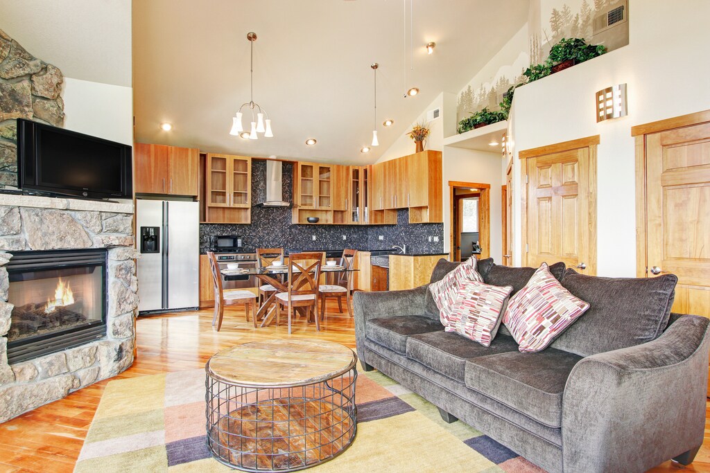 Open concept living room/kitchen with vaulted ceiling. With queen sleeper sofa, fireplace and flat screen TV