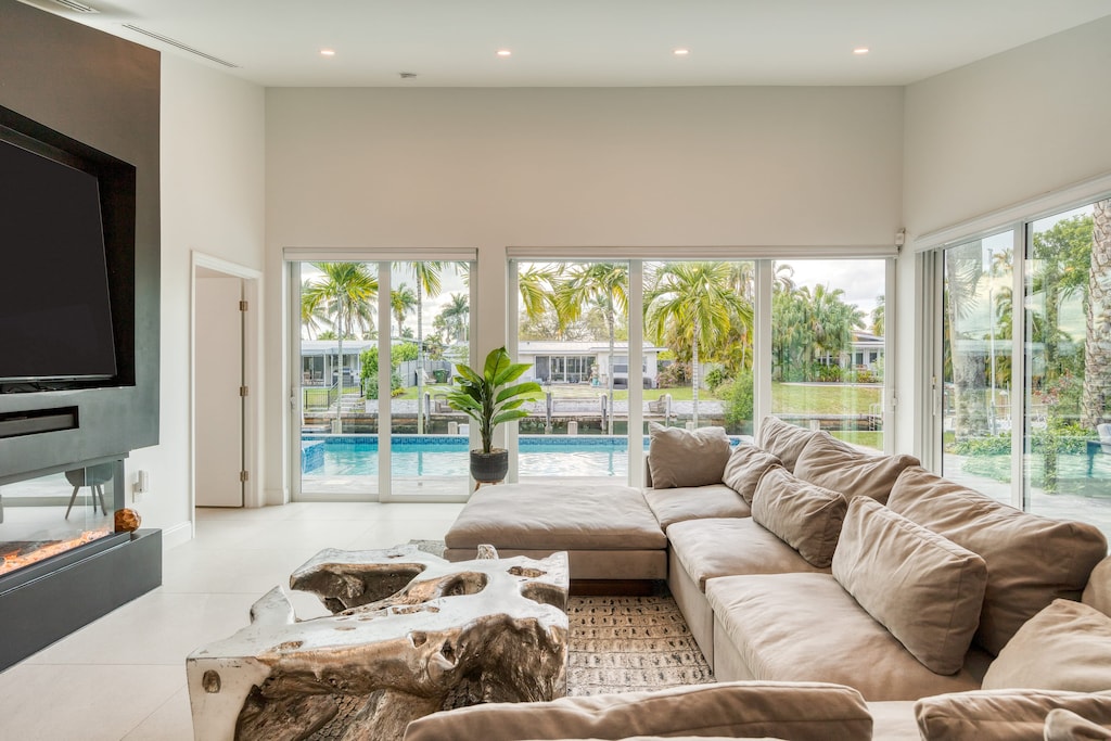 The living room offers cozy seating, a beautiful view of the pool, patio access and plenty of natural light.