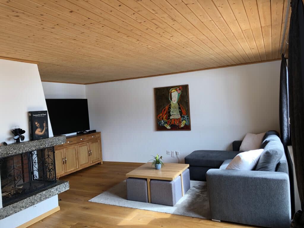 The living room features a sitting area with the TV and a beautiful, warm fireplace.