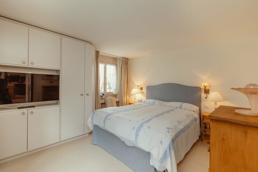 the bedroom with queen sized bed and personal tv 