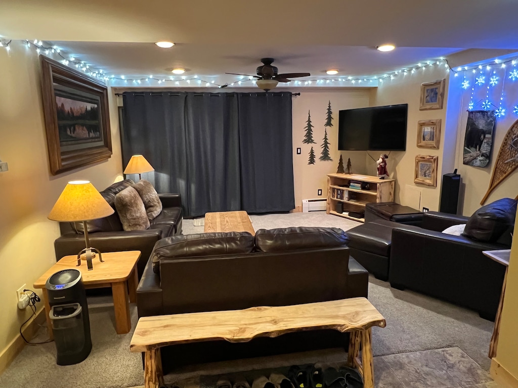 A cozy living room featuring leather couches and an armchair, a wooden coffee table, and TV