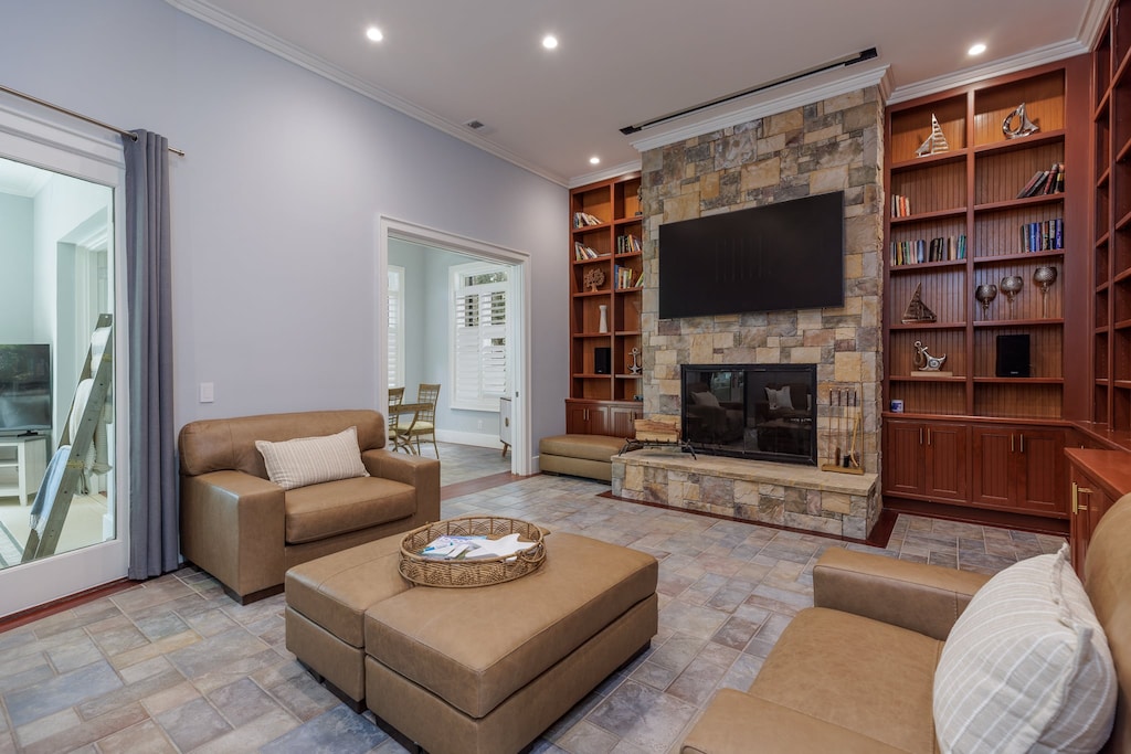 Inviting library lounge featuring built-in wood bookshelves, a stone fireplace, and comfortable leather seating—perfect for relaxing.