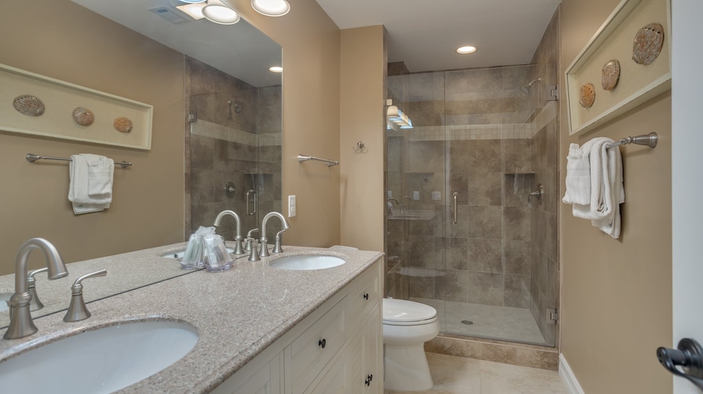 bathroom guest bathroom features a spacious vanity with ample storage, a solid-surface countertop, and a walk-in shower.