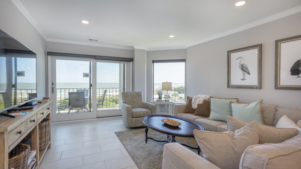 Bright and airy living area featuring coastal furnishings and sliding doors that open to your private oceanfront balcony with sweeping Atlantic views.