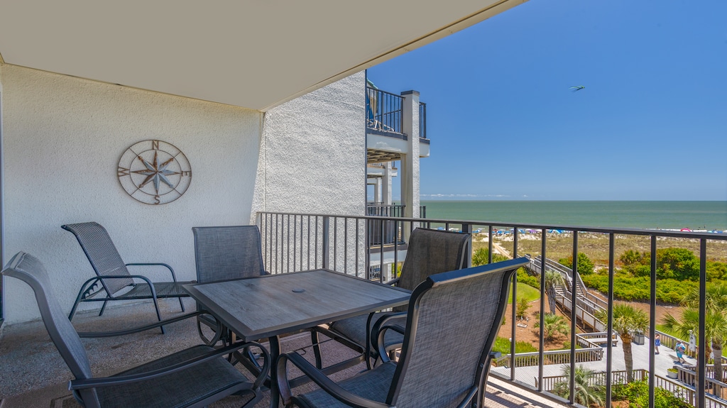Enjoy an oceanfront private balcony with stunning views overlooking the complex pool—your perfect spot for morning coffee or a relaxing evening by the sea.