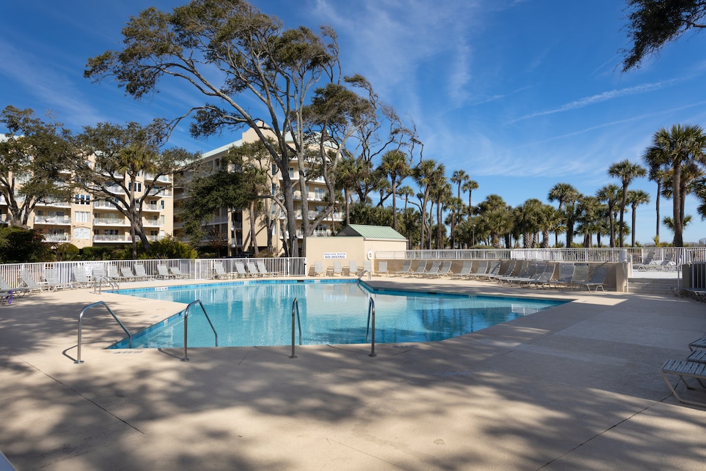 The community pool offers a resort-style setting surrounded by swaying palms and open skies—perfect for cooling off after a day at the beach.