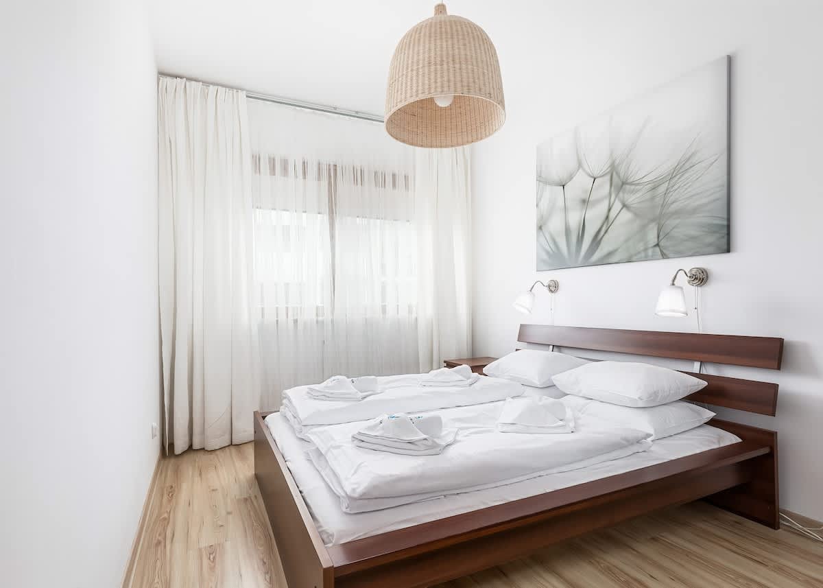 
Cosy, bright bedroom with double bed. A rattan lamp hangs from the ceiling which matches the overall design. 