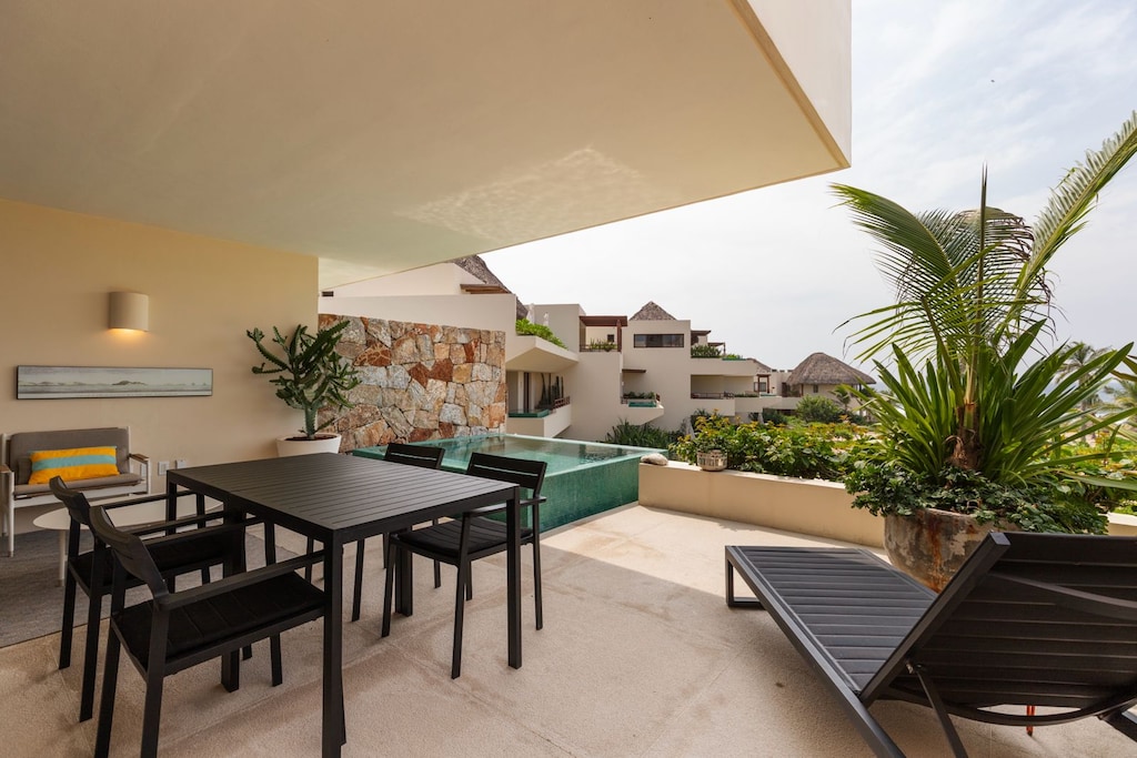 Dine al fresco by your private pool with ocean views, featuring comfortable seating and sun loungers for ultimate relaxation.