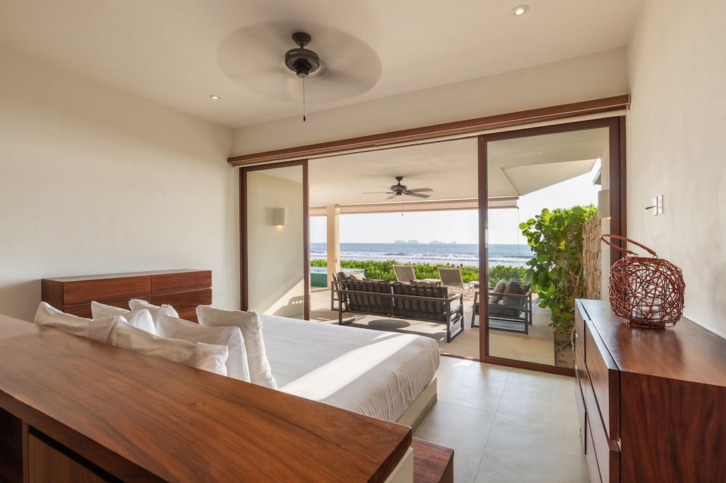 A peaceful retreat featuring a plush king-size bed, warm lighting, and private access to a scenic terrace.