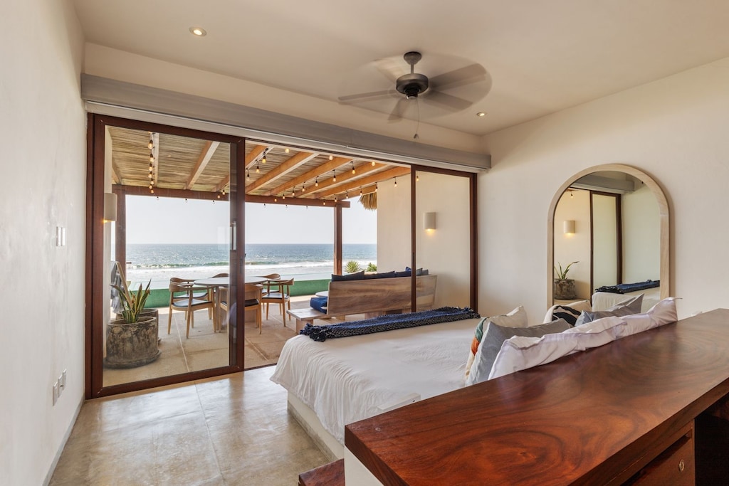 Wake up to breathtaking ocean views from this elegant master bedroom, featuring floor-to-ceiling windows and seamless terrace access.