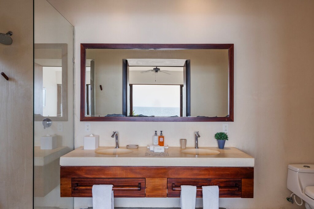 A luxurious bathroom featuring a double vanity, sleek fixtures, and natural lighting for a refreshing experience.