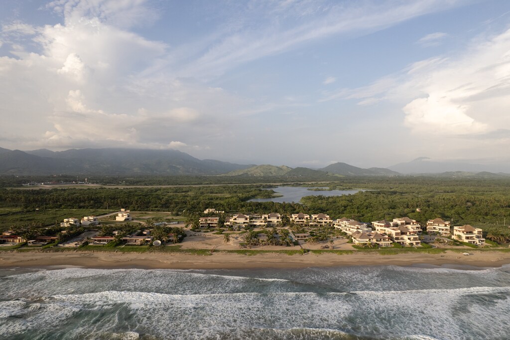 Nestled between lush greenery and the ocean, this serene community offers stunning views and private beach access.