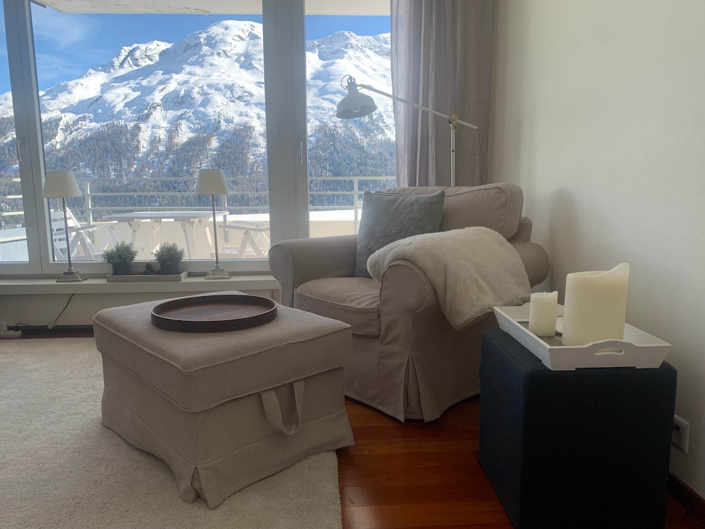 
Cuddle up with a blanket and enjoy a warm drink as you soak in the breathtaking view of snow-capped mountains from the comfort of this cozy living room.
