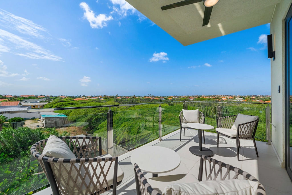 - Unwind with panoramic views on this elegant balcony overlooking greenery and vibrant rooftops - Cozy seating and a refreshing breeze make it the ideal spot for morning coffee or evening drinks - A serene outdoor retreat with endless vistas